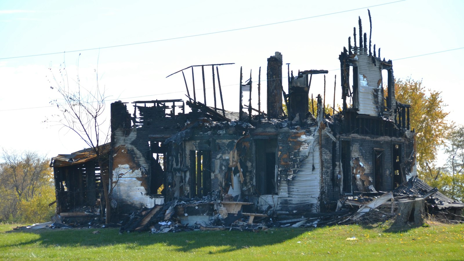 A fire-damaged house structure standing before demolition, illustrating a fire-damaged California property being prepared for sale or rebuild
