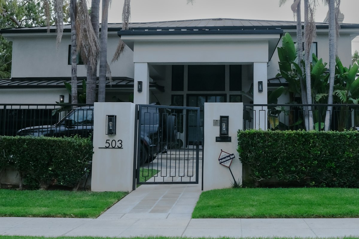 Modern house exterior with manicured hedges and gate