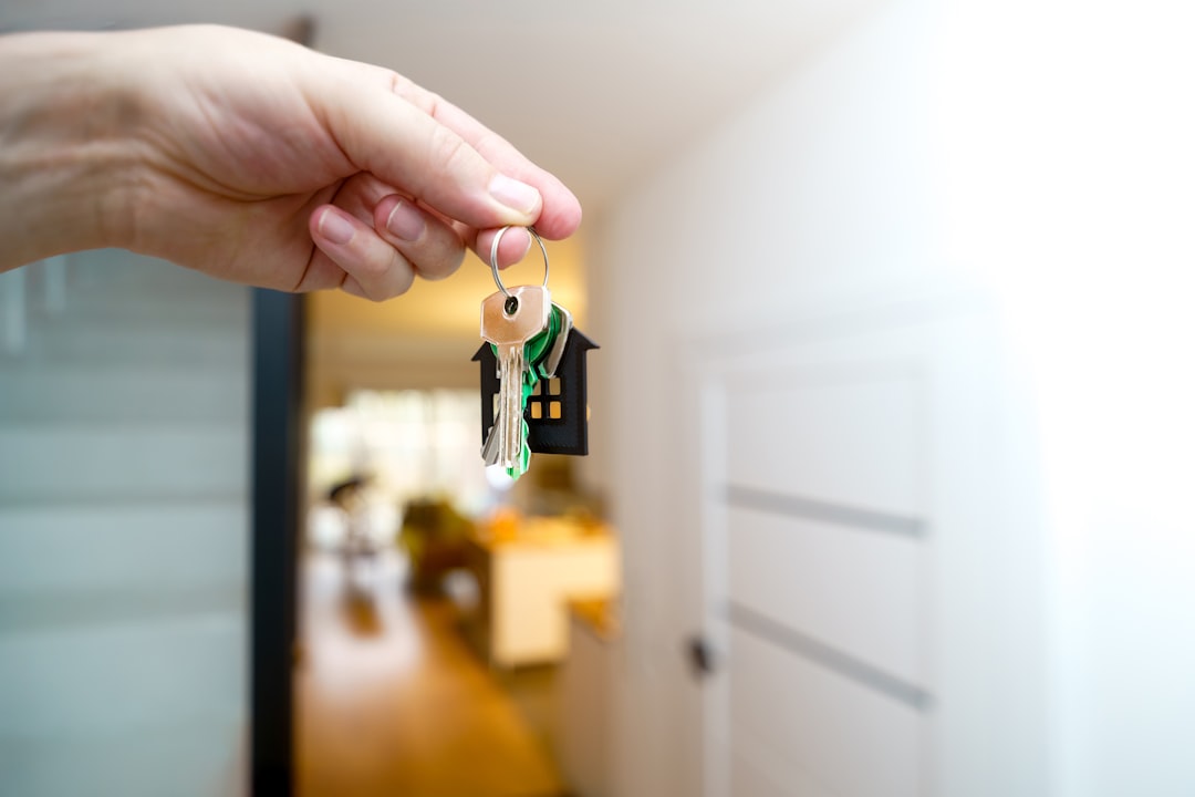 Hand holding house keys at a home, representing property transfer during probate
