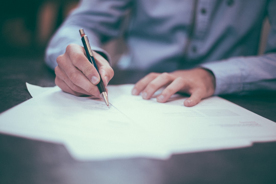 Hands signing a real estate document at a desk